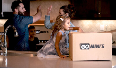 A happy family in a kitchen with Go Mini's moving boxes on counters